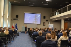 uczestnicy konferencji siedzą na auli, przy mównicy prowadząca