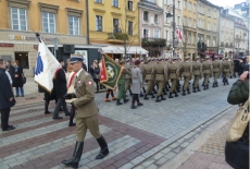 Środkiem ulicy idą żołnierze z trumną.