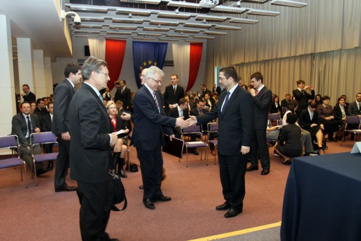 fot. KSAP/Sebastian Szulfer Widok na aule Dyrektor Jacek Czaputowicz wręcza dyplom jednemu z absolwentów, obok stoi Leszek Balcerowicz